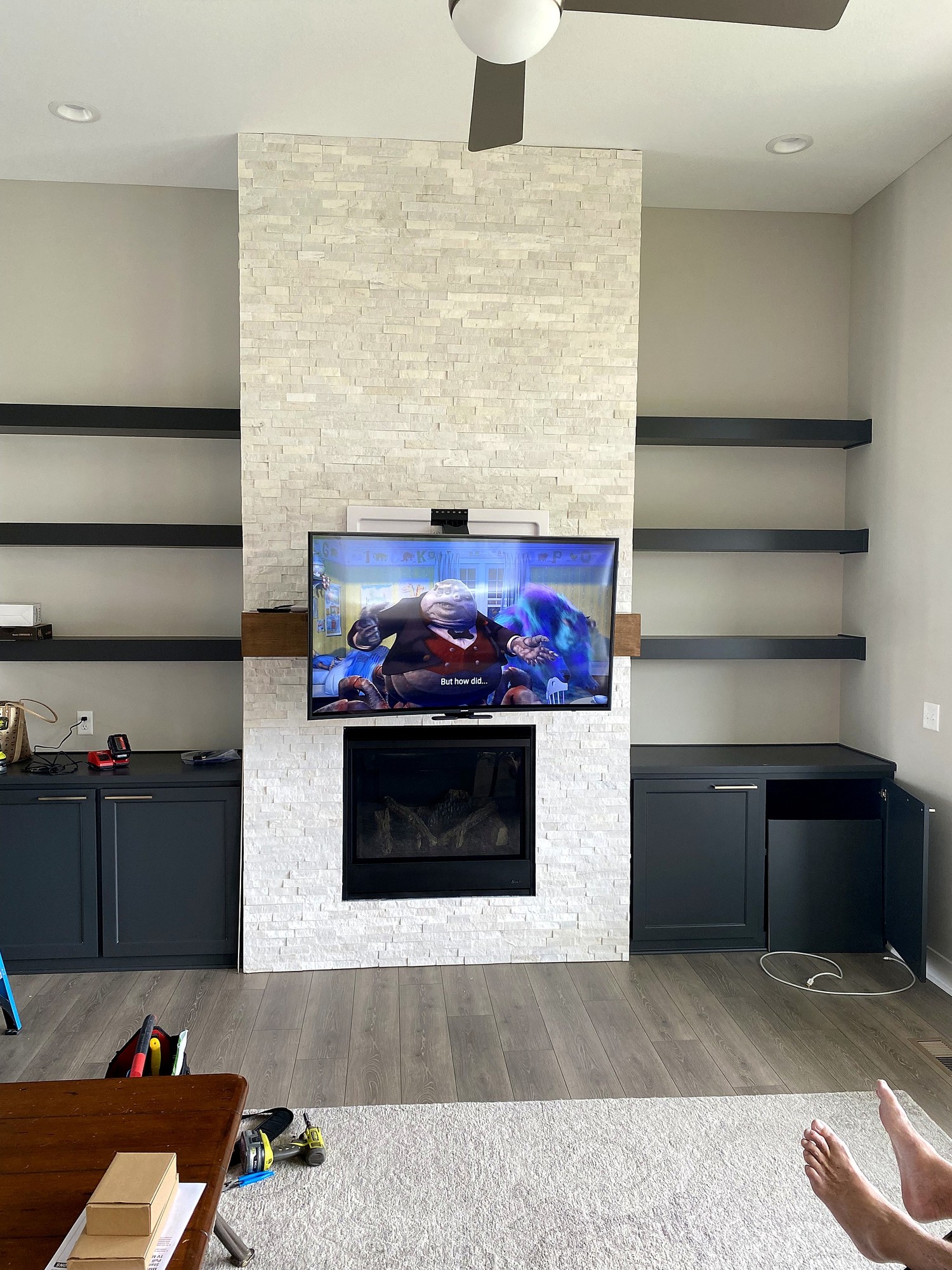 MantelMount TV pulled down over a stone fireplace in a Kansas City home