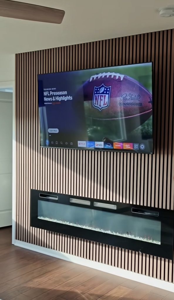 Mounted TV and linear electric fireplace on wood slat panels in a Kansas City home